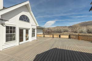 Wooden deck with a mountain view and french doors