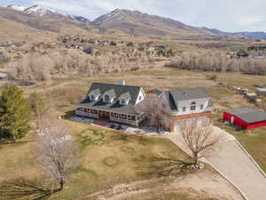 Aerial view of property and surrounding area featuring a mountain backdrop