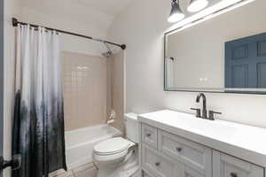 Bathroom featuring vanity, shower / tub combo, and light tile patterned floors
