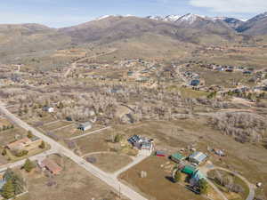 Aerial overview of property's location with a mountainous background and nearby suburban area