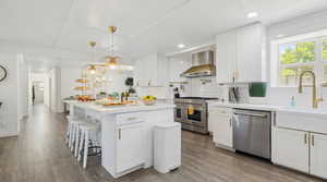 Kitchen featuring stainless steel appliances, dark wood-style floors, and white cabinetry