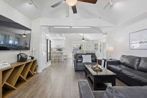 Living area with rail lighting, dark wood finished floors, and vaulted ceiling