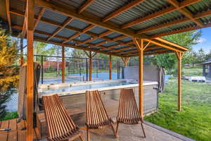 View of patio with a hot tub