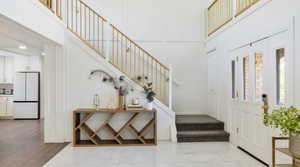 Entrance foyer with a high ceiling and light marble finish flooring