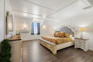Bedroom with dark wood finished floors and a decorative wall