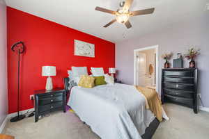 Bedroom featuring a ceiling fan, carpet flooring, and ensuite bathroom