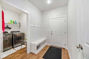 Laundry area with light wood-type flooring and washer and dryer