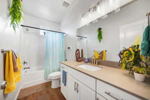 Bathroom featuring vanity, dark wood finished floors, and shower / bath combo with shower curtain