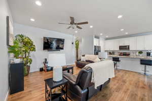 Living area featuring ceiling fan, light wood-type flooring, and recessed lighting