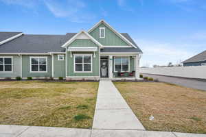 View of front of house with board and batten siding, a porch, and a shingled roof