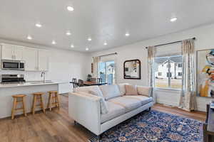 Living area with dark wood-style floors, healthy amount of natural light, and recessed lighting