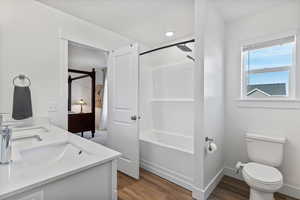 Bathroom featuring double vanity, light wood finished floors, and shower / bath combination