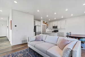 Living room with dark wood-style flooring and recessed lighting