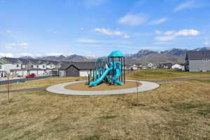Community playground with a residential view, a yard, and a mountain view