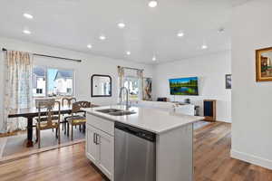 Kitchen with dishwasher, light wood-type flooring, an island with sink, healthy amount of natural light, and recessed lighting