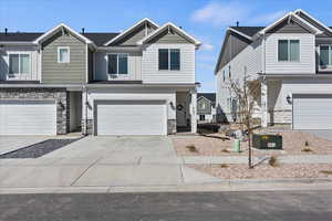 Craftsman inspired home with stone siding, concrete driveway, a garage, and board and batten siding