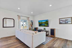 Living area with wood finished floors and recessed lighting