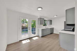 Kitchen with gray cabinets, light wood-type flooring, french doors, and electric stove