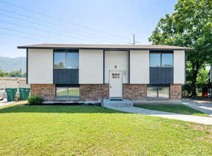 View of front of house with a front yard and brick siding
