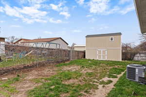Fenced backyard featuring an outbuilding