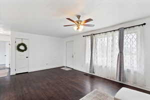 Foyer with dark wood-style floors and ceiling fan