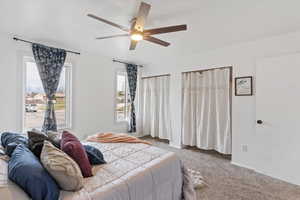 Carpeted bedroom with a ceiling fan
