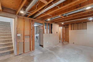 Unfinished basement with stairway and washer / dryer