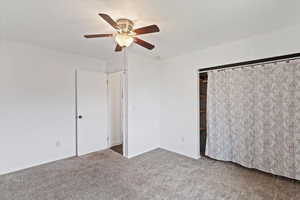 Unfurnished bedroom featuring carpet floors, a ceiling fan, and a closet