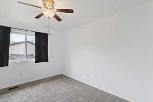 Empty room with ceiling fan and carpet flooring