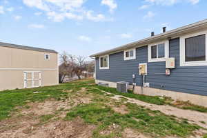 View of side of property featuring a cooling unit and an outdoor structure