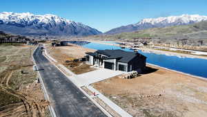 Aerial view of property and surrounding area with a water and mountain view