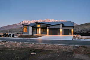 Contemporary house featuring a mountain view, an attached garage, and driveway