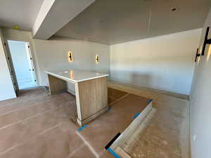 Kitchen featuring light countertops, wood finish cabinetry, modern cabinets, and a kitchen island