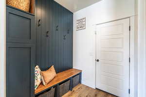 Mudroom featuring light wood-style floors and wooden walls