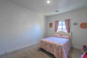 Bedroom with baseboards and light carpet