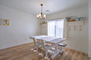 Dining room with light wood-type flooring and hanging lights