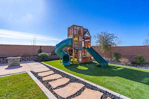 View of jungle gym with a fenced backyard