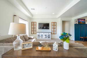 Living room featuring a tray ceiling and recessed lighting