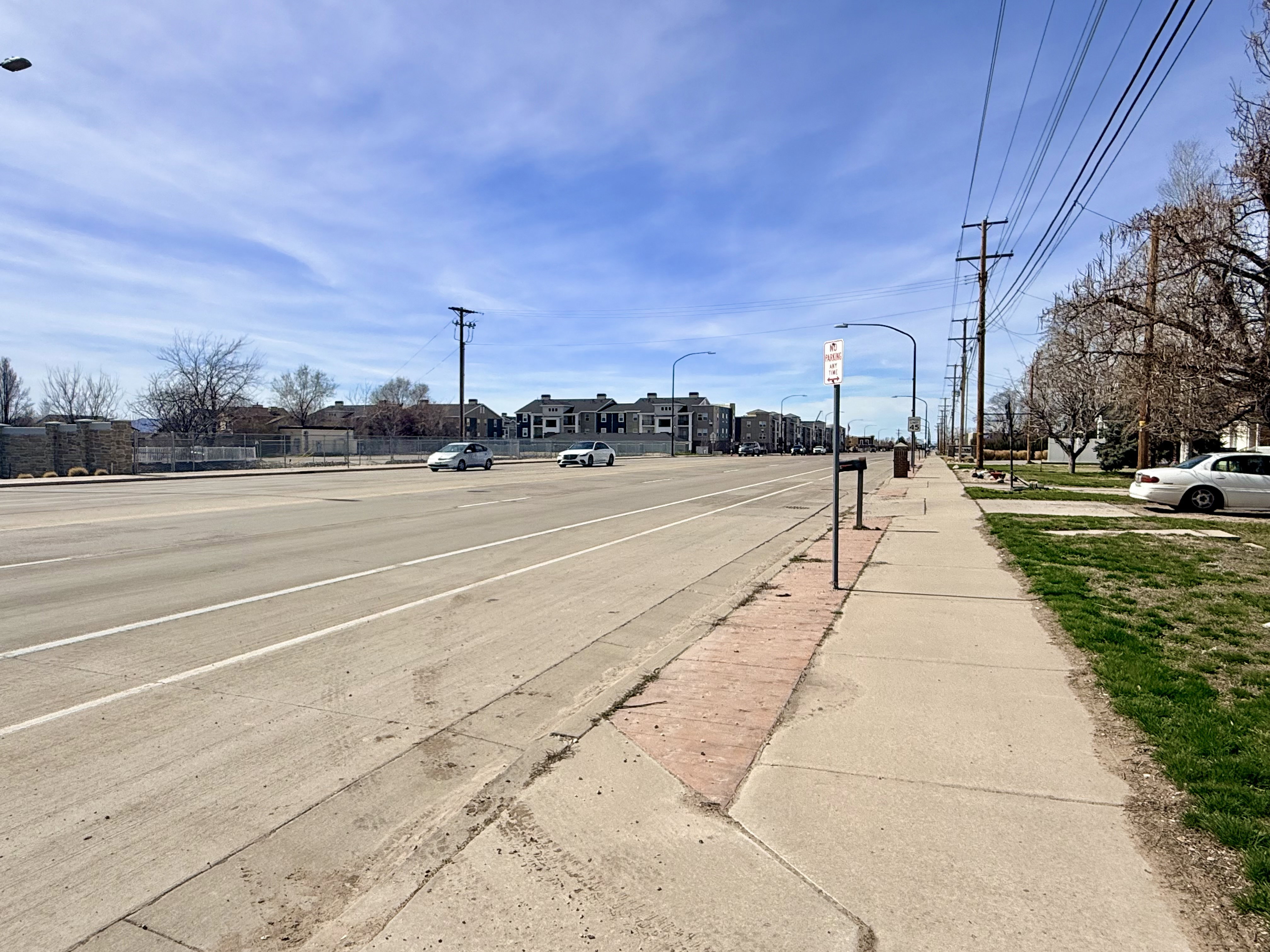 View of concrete road featuring street lighting and sidewalks