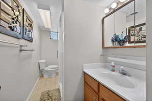 Full bath featuring a textured ceiling, vanity, and light tile patterned flooring