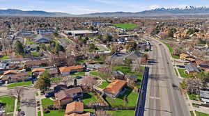 Aerial view of property and surrounding area with a mountainous background and nearby suburban area