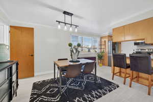 Dining space with ornamental molding and track lighting