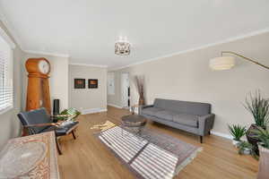 Living area featuring crown molding and light wood-style flooring