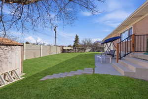 Fenced backyard featuring entry steps