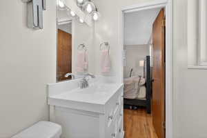 Ensuite bathroom with vanity and light wood-style floors