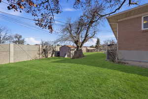 Fenced backyard with a storage unit