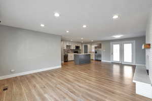 Unfurnished living room featuring light wood-style floors, recessed lighting, and a fireplace