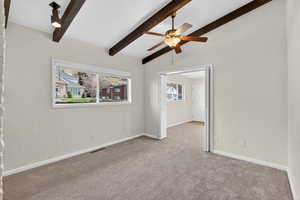 Flex-room featuring lofted beamed ceilings and a stately brick fireplace. Would make a great home office or music room with neutral carpeting, natural light and character.