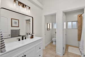 Updated bathroom featuring a new vanity suite, light tile flooring, and a shower/tub combination. A private water closet adds a functional touch to this bright space.