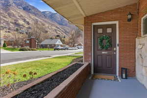 Inviting covered porch where mountain views provide a serene backdrop. The brick and natural stone exterior adds a classic touch while the seamless no-step entrance offers accessibility.